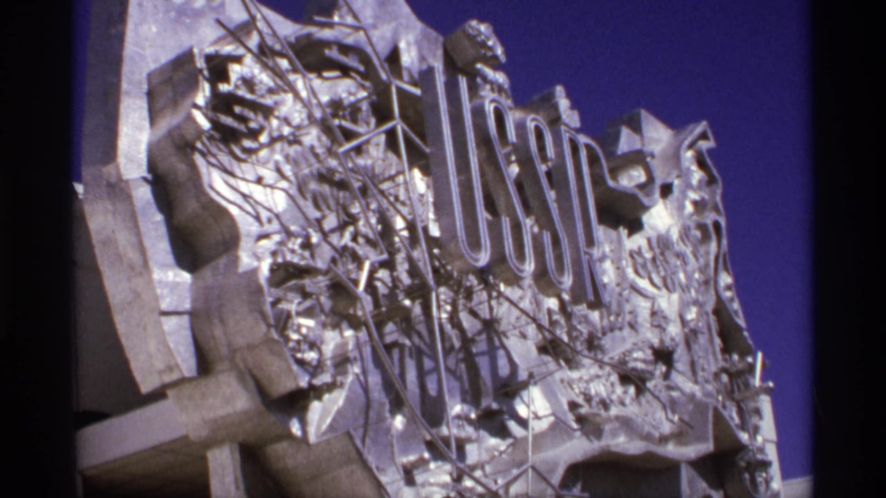 Angled view of a large USSR sign mounted on a sculptural exterior.