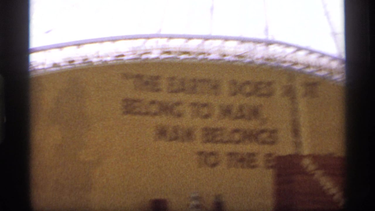 Blurred continuation of the wall quote on a large display surface.