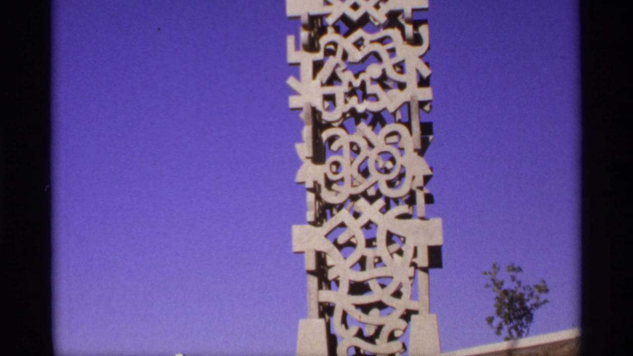 Tall carved white monument against a deep blue sky, framed near the top.