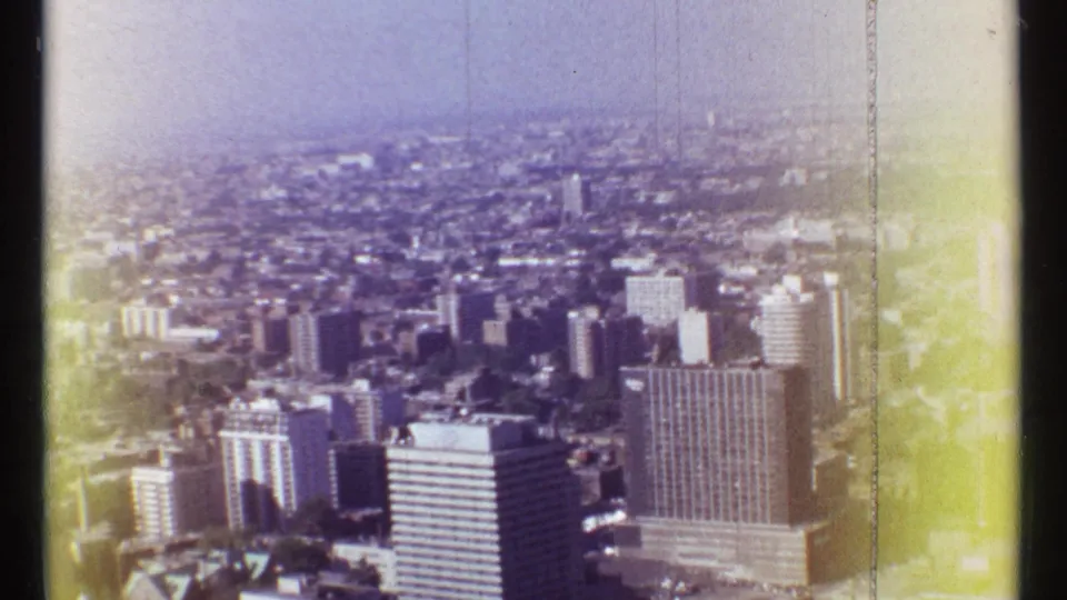 Montreal aerial skyline view showing clustered high-rises, urban density, and visible 8mm edge fading.