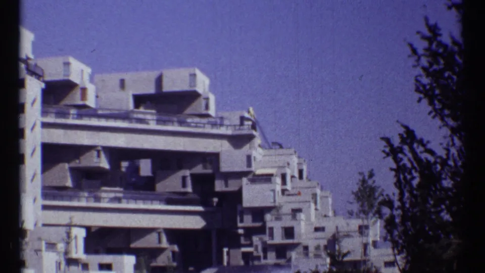 1967 Montreal 8mm frame with Habitat 67's terraced concrete modules and balcony railings visible.