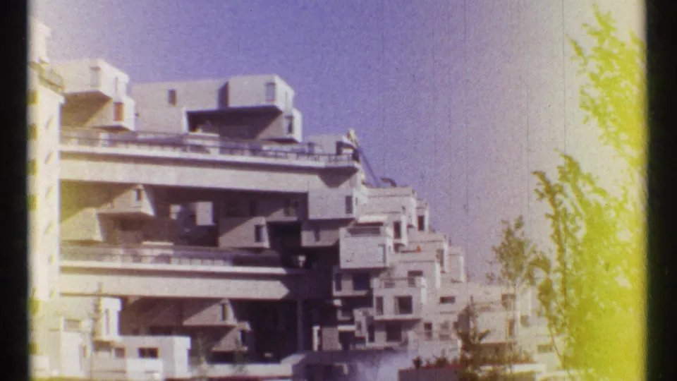 Habitat 67 appears in a 1967 Montreal home-movie frame, partly cropped with trees and yellow edge flare.