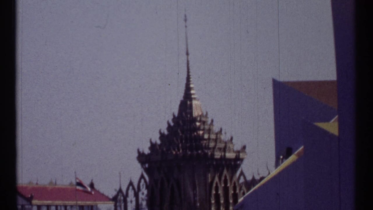Decorative spire, flags, pavilion shapes, and part of a geodesic dome under a clear sky.
