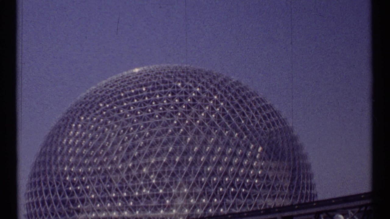 Upper half of a geodesic dome with triangular lattice against a blue sky.