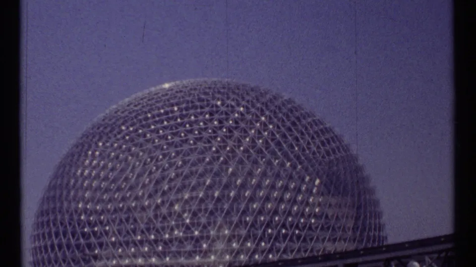 The Expo-era geodesic dome in Montreal fills the frame, its triangular lattice catching light beneath a blue sky.