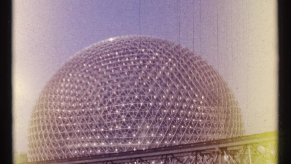 The Montreal geodesic dome appears through warm faded 8mm color, with its lattice and foreground railing still visible.
