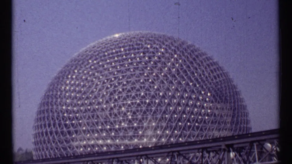 Montreal Expo 67 geodesic dome seen behind an elevated track in a 1967 8mm home-movie frame.