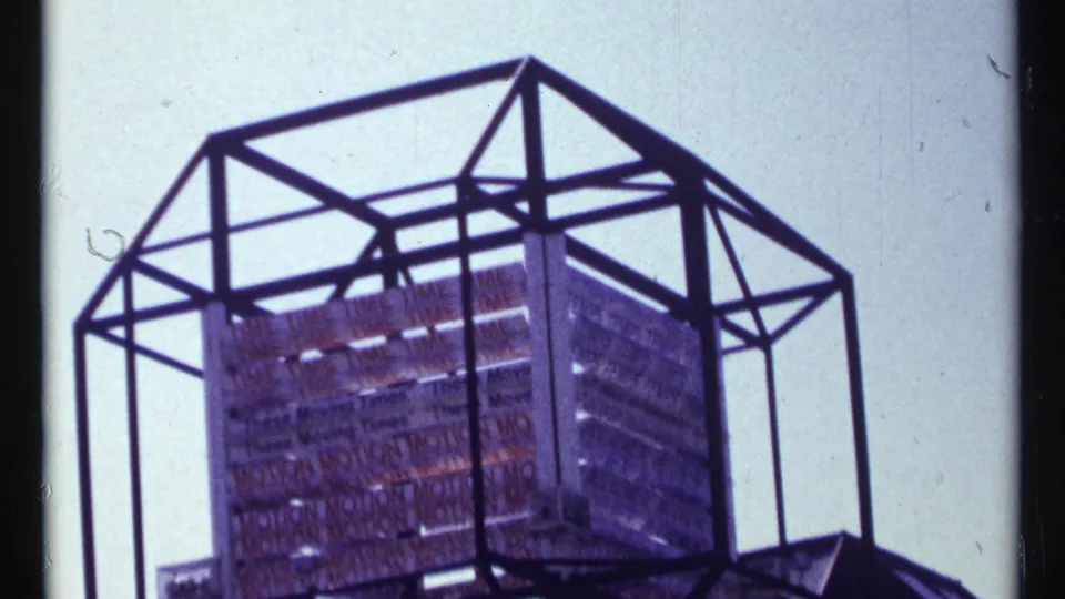 A geometric metal frame and gridded display structure at Expo 67, filmed from below on 8mm stock.