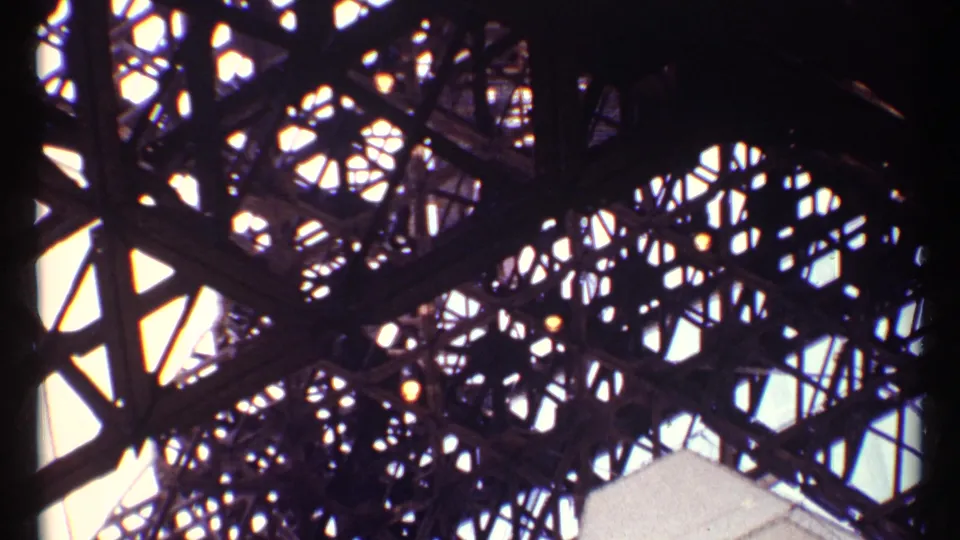 8mm frame from Montreal showing dense monument latticework silhouetted against sunlit sky.