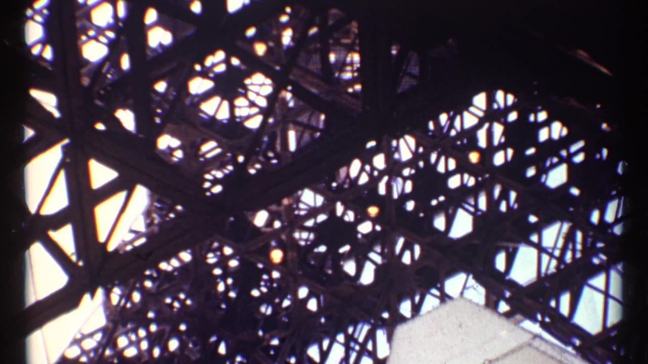 Low-angle 1967 Montreal view of overlapping steel trusses and geometric openings silhouetted against daylight.
