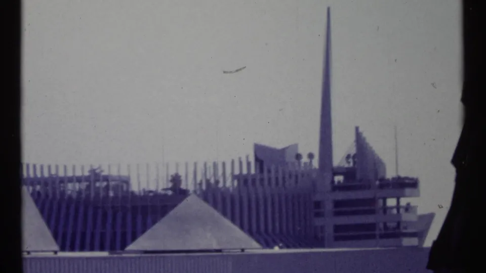 Final 1967 Montreal frame holding on a modernist roofline, vertical spire, ribbed wall, and angular building forms.