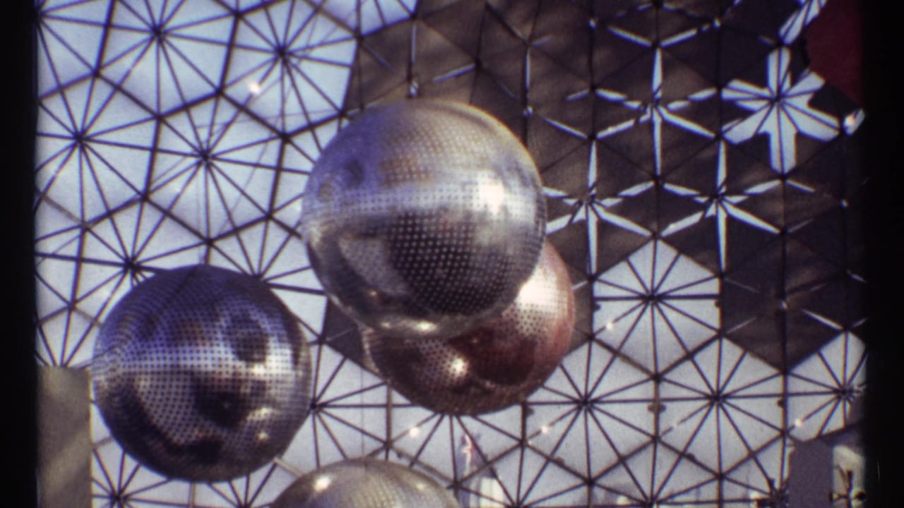 Reflective spheres hang inside a geometric dome lattice.