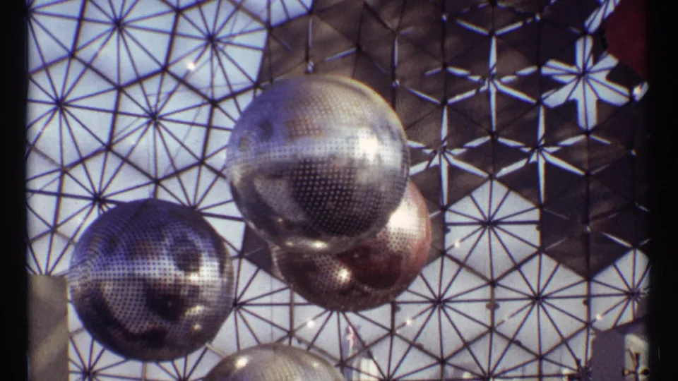 1967 Montreal footage shows mirrored spheres suspended beneath a geodesic dome framework.