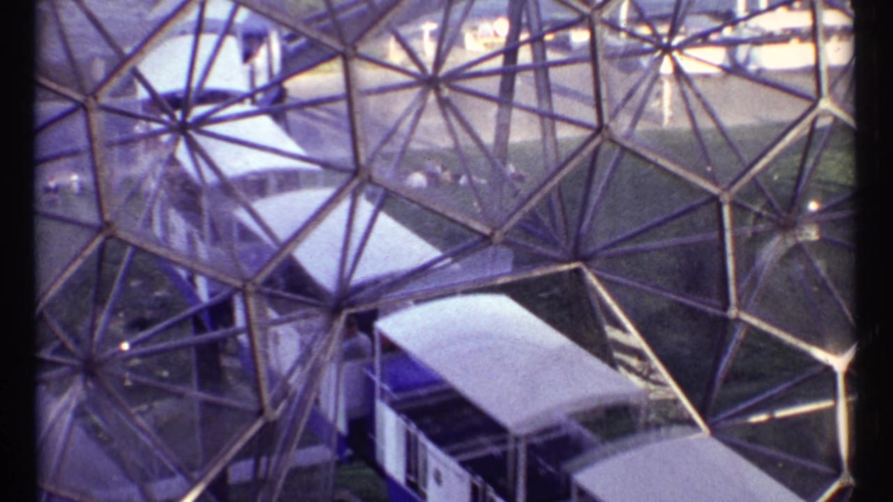 Trolley cars move past the triangular glass framework of the dome.