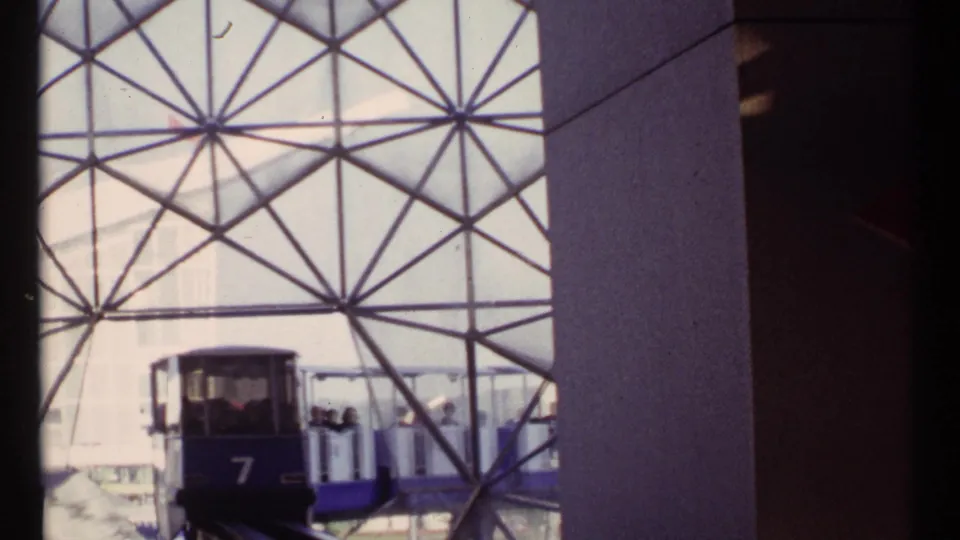 The front trolley car, marked 7, sits or moves inside the Montreal geodesic dome with passengers in the following car.