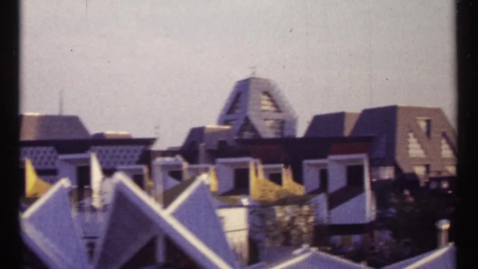 Montreal public waterfront area with white angular roof forms, flags, pedestrians, and distinctive geometric buildings in the background.