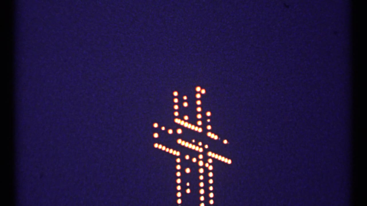 1967 Montreal 8mm frame with a warm dotted cross outline glowing against a deep blue-black night sky.