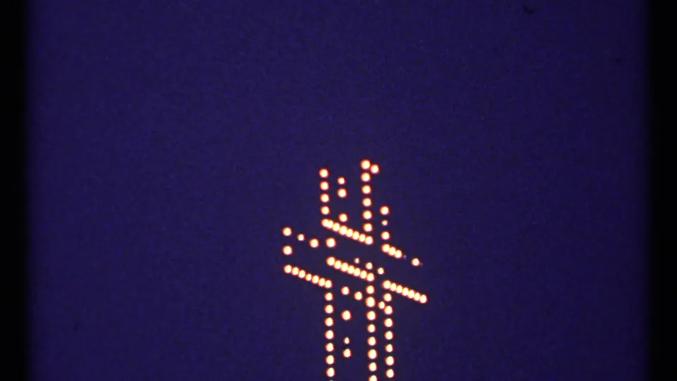 1967 Montreal 8mm frame with a warm dotted cross outline glowing against a deep blue-black night sky.