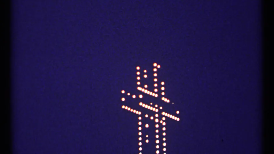 1967 Montreal 8mm frame with the glowing dotted cross positioned lower right against deep blue night sky.