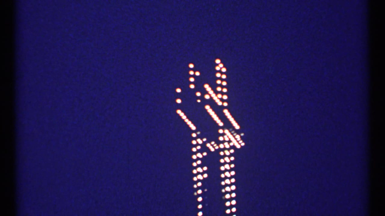 White bulb-lit cross outline against a deep blue evening sky.