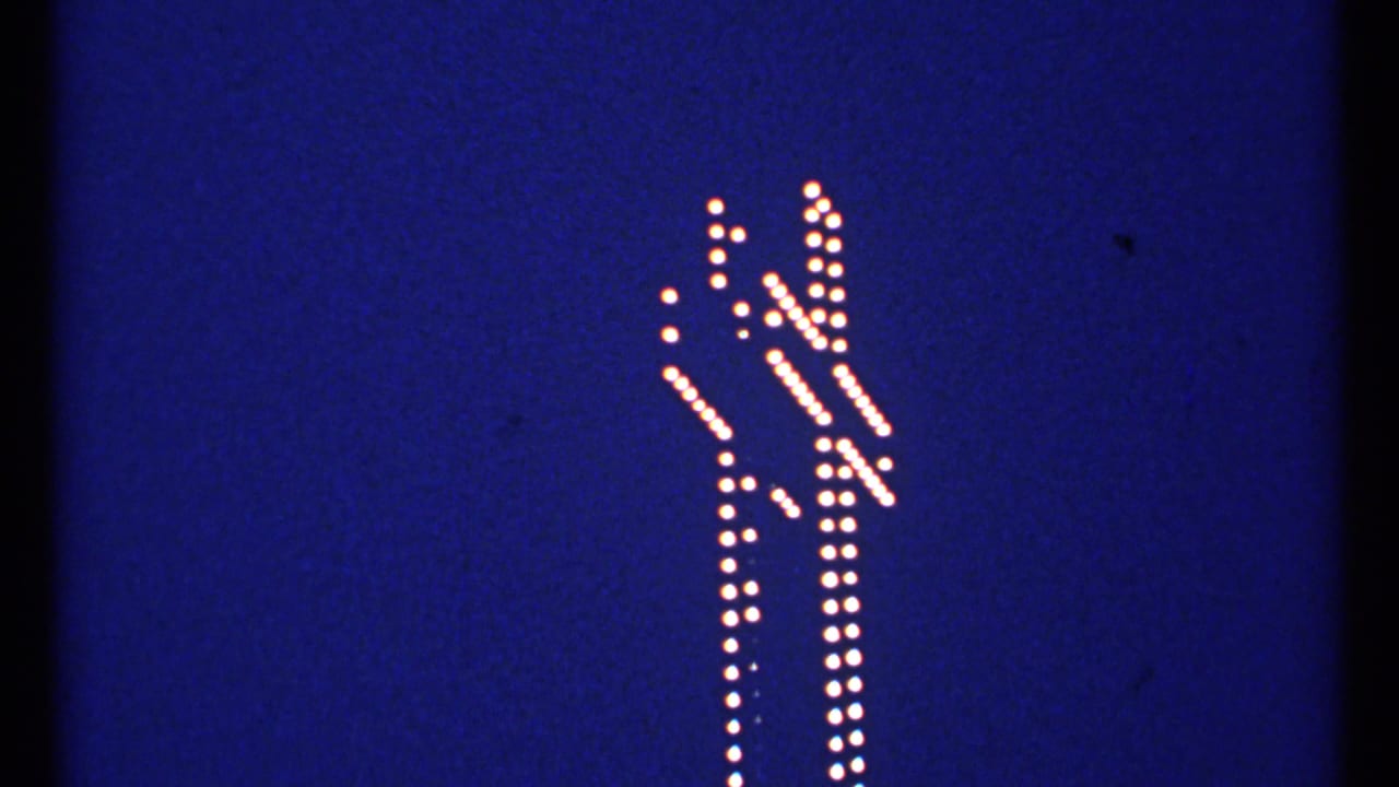 Bulb-lit white cross shape centered on a blue evening background.