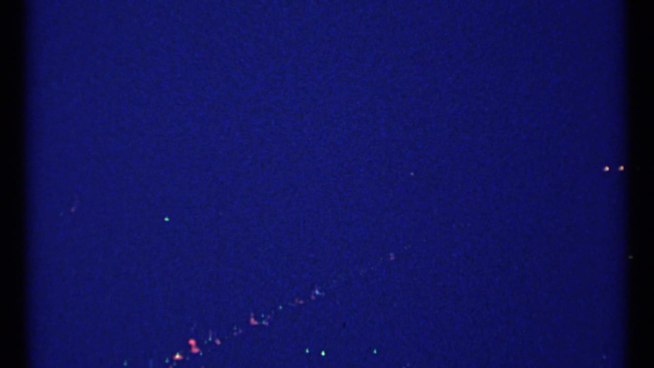 Dark blue frame with faint distant lights near the lower edge.