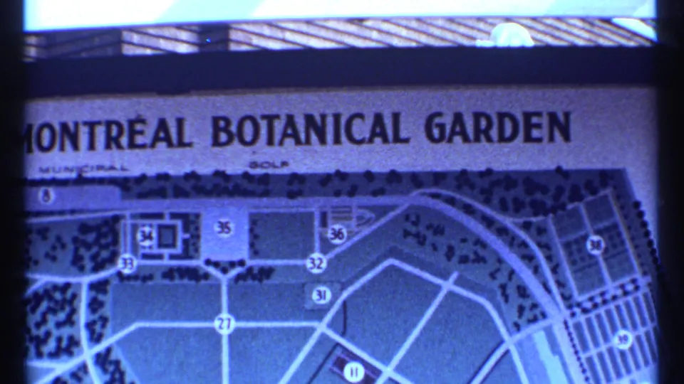 1967 Montreal home-movie frame showing the Botanical Garden sign with a numbered garden map and path layout beneath the title.