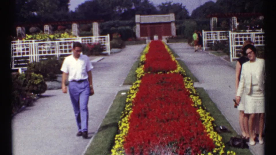 The final 1967 Montreal frame shows adults near the paved garden paths, with the red-and-yellow floral median centered between them.