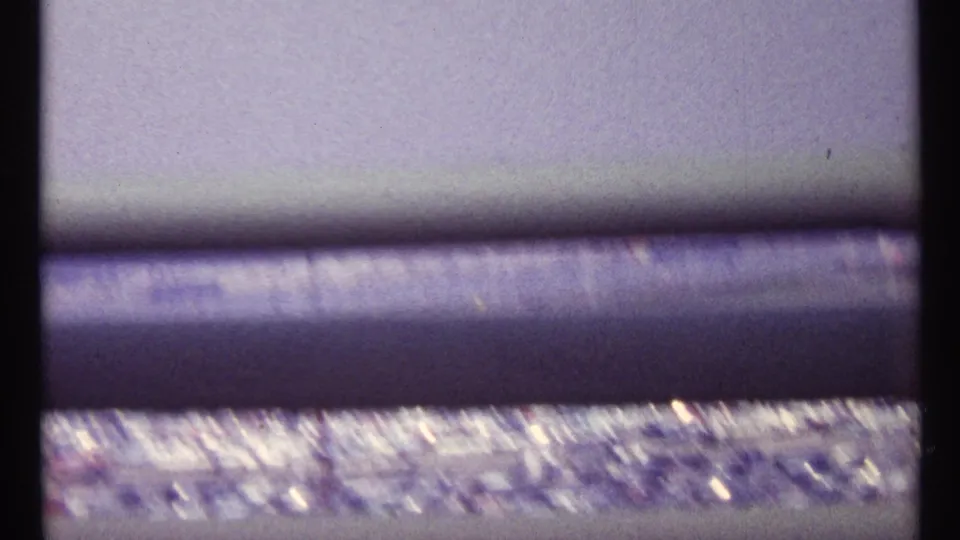 A soft, motion-blurred 1967 Montreal view of parked cars below heavy horizontal bridge railings.