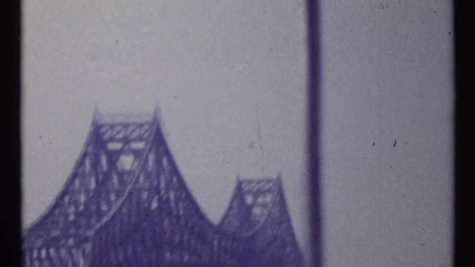 1967 Montreal 8mm view of steel truss bridge towers, likely filmed through a window from a moving vantage point.