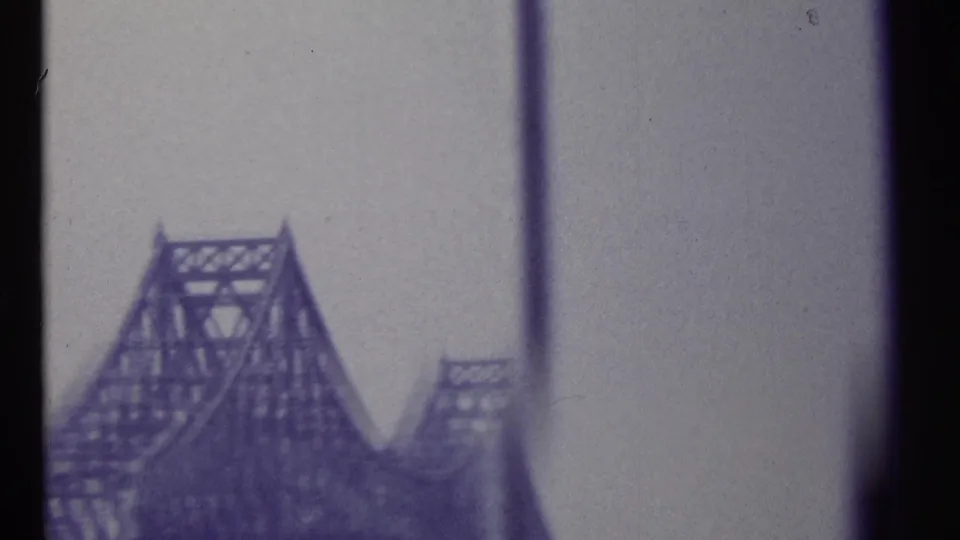 1967 Montreal frame showing a steel truss bridge through a window-like frame, with heavy grain and muted purple color shift.