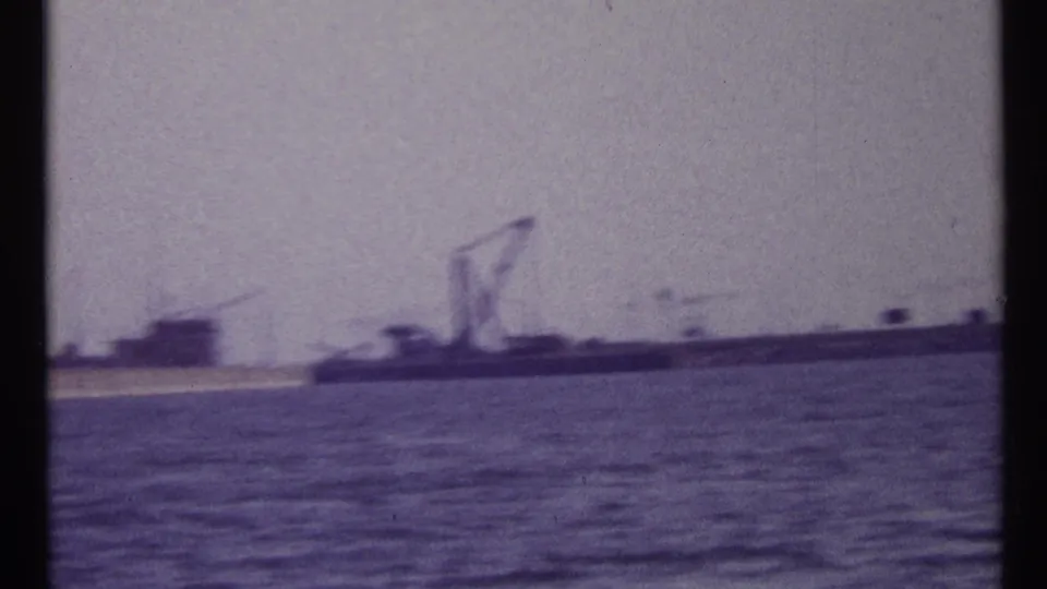 Soft 8mm frame of Montreal harbor water with distant industrial forms and cranes appearing through haze.