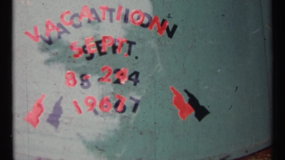 Tighter 8mm frame of the Ottawa vacation title card, showing the September 1967 date and painted arrow shapes on teal.