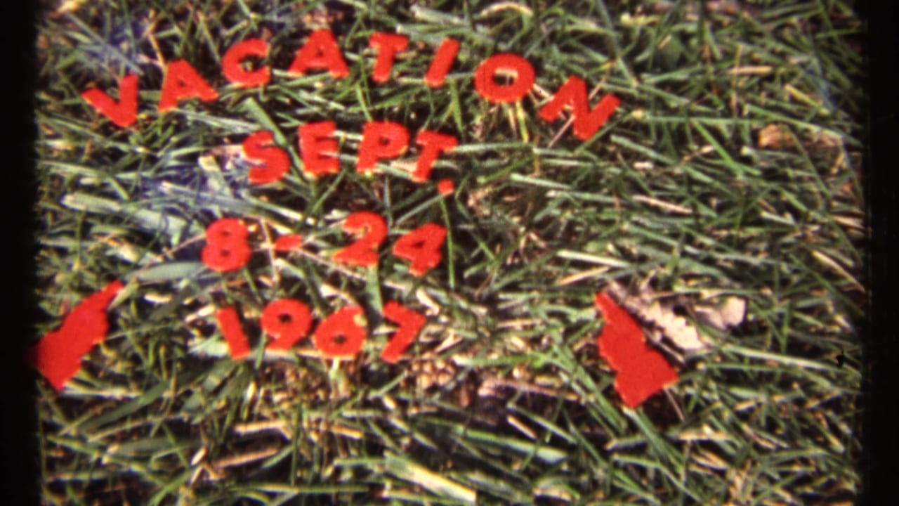 Repeated vacation date title card on grass.