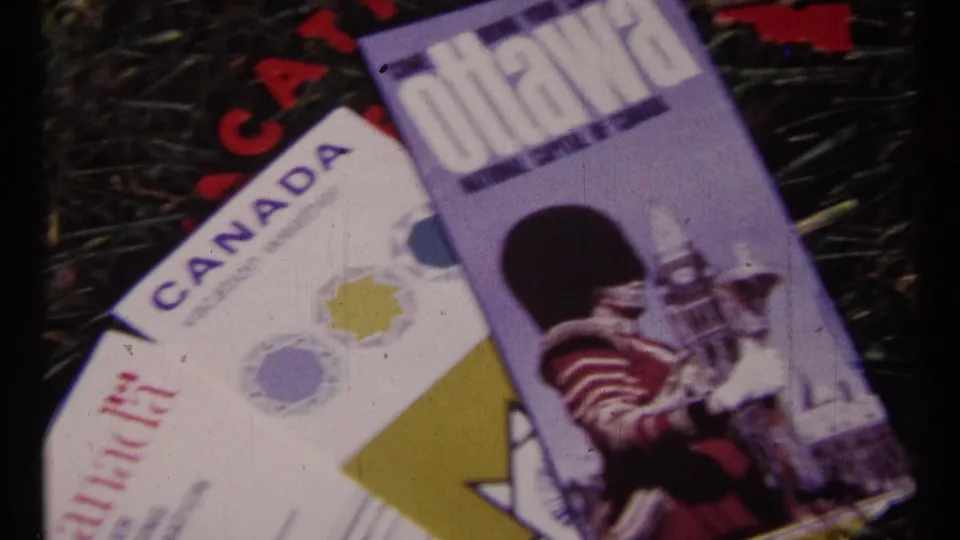 Ottawa travel brochure and Canada vacation weather material on grass, including printed artwork of a guard and Parliament Hill imagery.