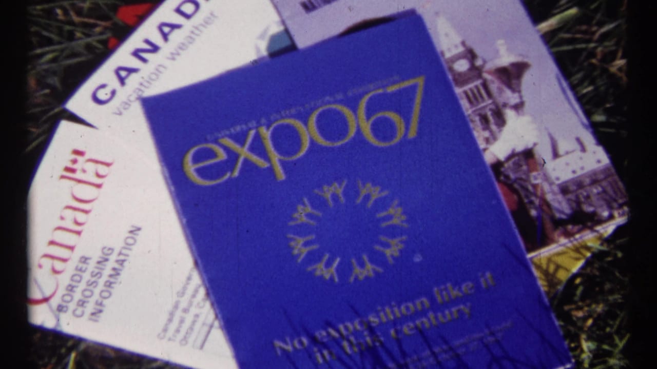 Blue Expo 67 brochure and Canada border-crossing paperwork lying on grass.