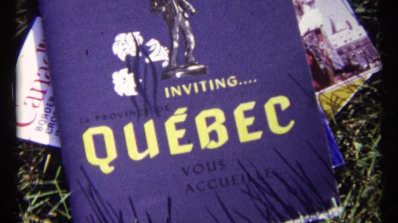 Purple Quebec travel pamphlet partly covering other brochures on grass.
