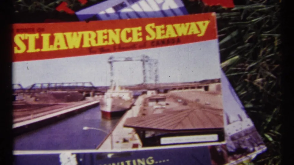 1967 Ottawa frame showing a red and white St. Lawrence Seaway brochure with ship and lock imagery on grass.