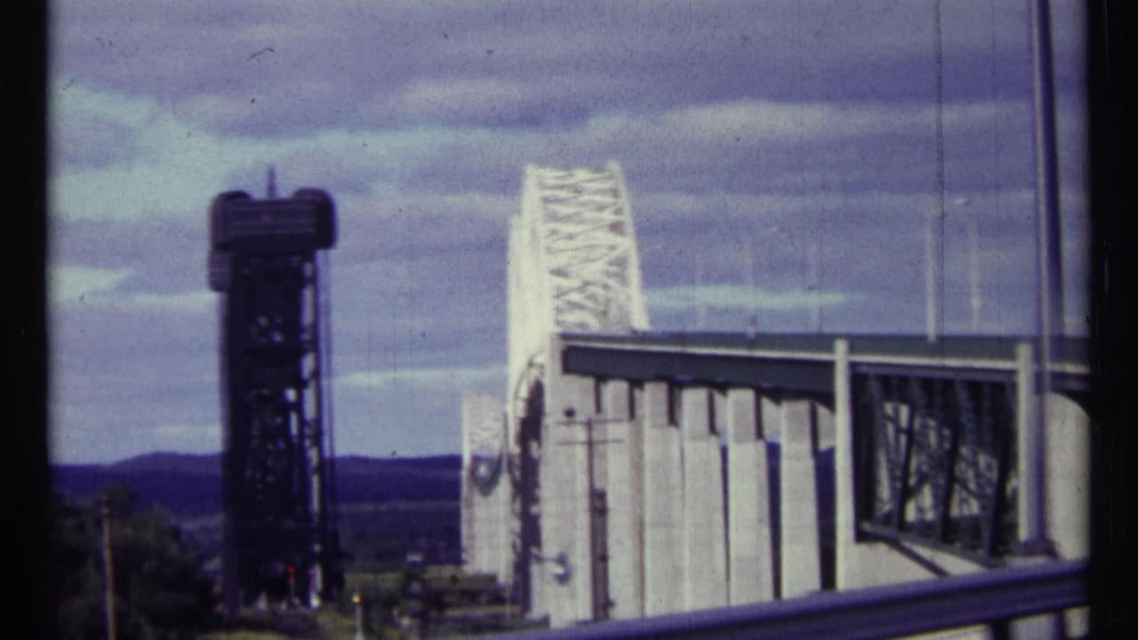 1967 Ottawa sightseeing footage frames the bridge control tower, white truss span, roadside rail, and cloudy blue sky.