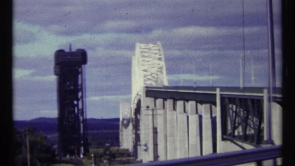 1967 Ottawa sightseeing footage frames the bridge control tower, white truss span, roadside rail, and cloudy blue sky.