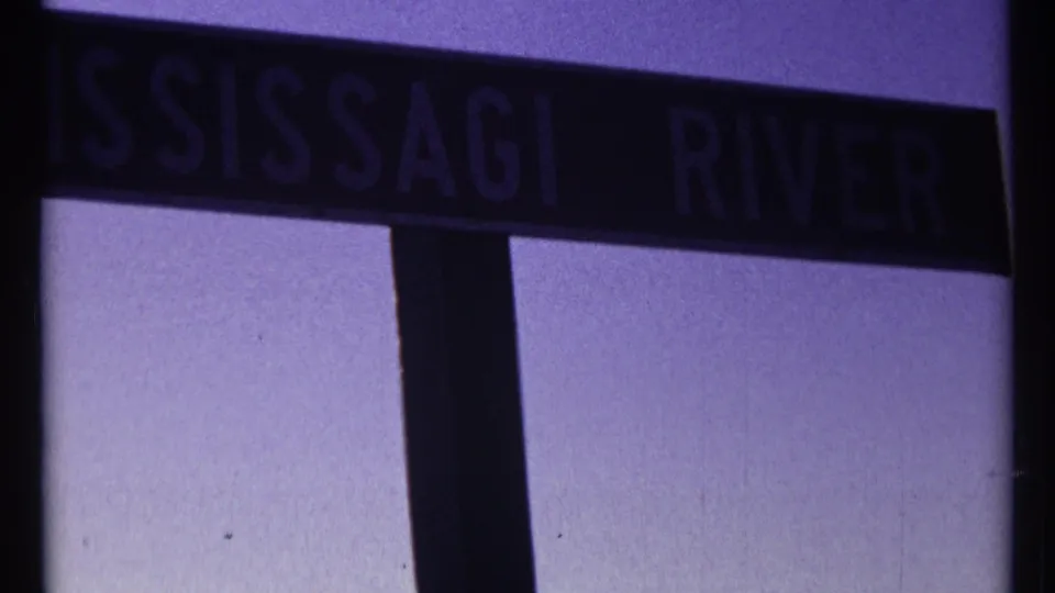 1967 8mm close-up of the MISSISSAGI RIVER sign, partly cropped as the camera moves past.