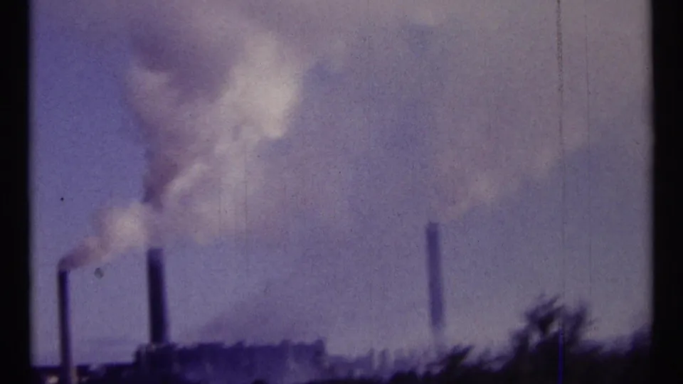 Soft 8mm view of Ottawa industrial smokestacks with smoke drifting across a purple-tinted sky.
