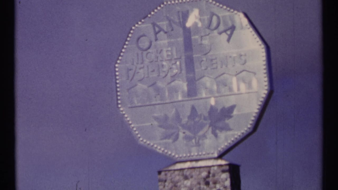 Large octagonal Canadian coin monument against a purple sky.