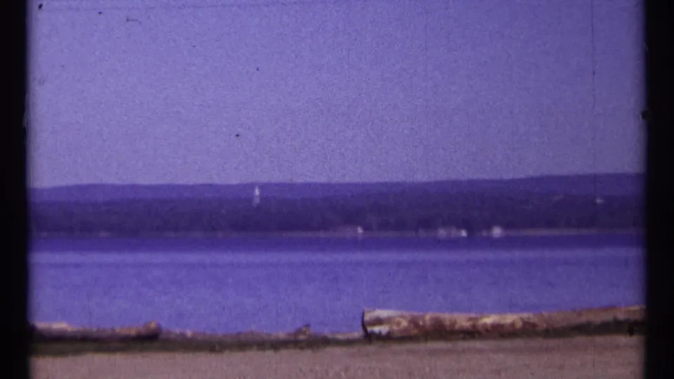 1967 Ottawa-area home-movie view of calm water and a low distant shoreline before the Parliament shots.
