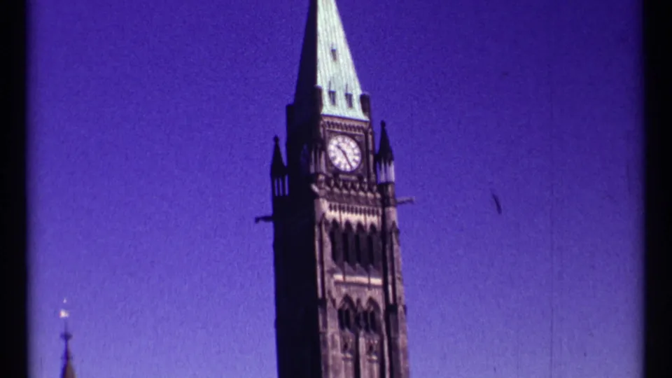 Vertical 1967 Ottawa framing on the Peace Tower, with clock face, green roof, and adjacent roofline visible.