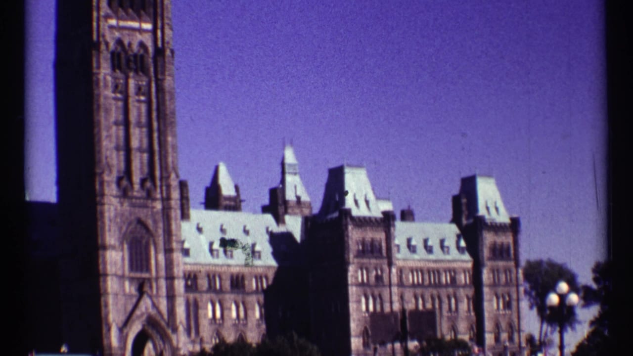 Parliament Buildings with the Peace Tower partly visible under a purple-blue sky.