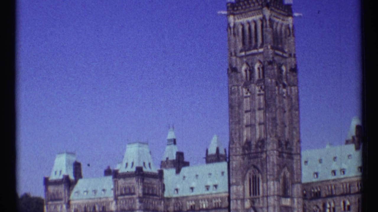 Parliament roofline and Peace Tower centered against a clear blue sky.