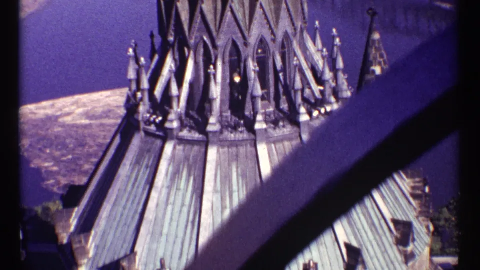 1967 Ottawa 8mm frame holding on Gothic Revival roof forms, spires, and a shadowed beam in blue twilight color.