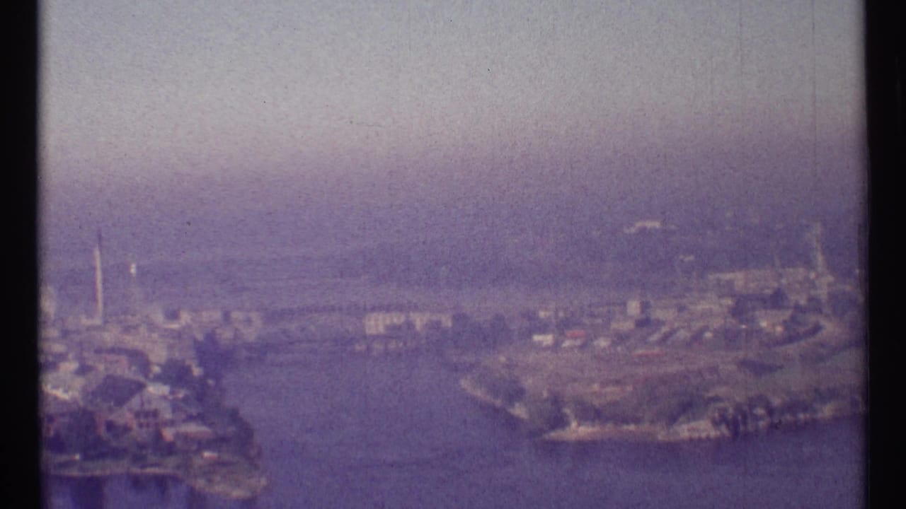 Ottawa, Canada, in 1967, seen from above with river water, developed shorelines, scattered buildings, and soft haze.