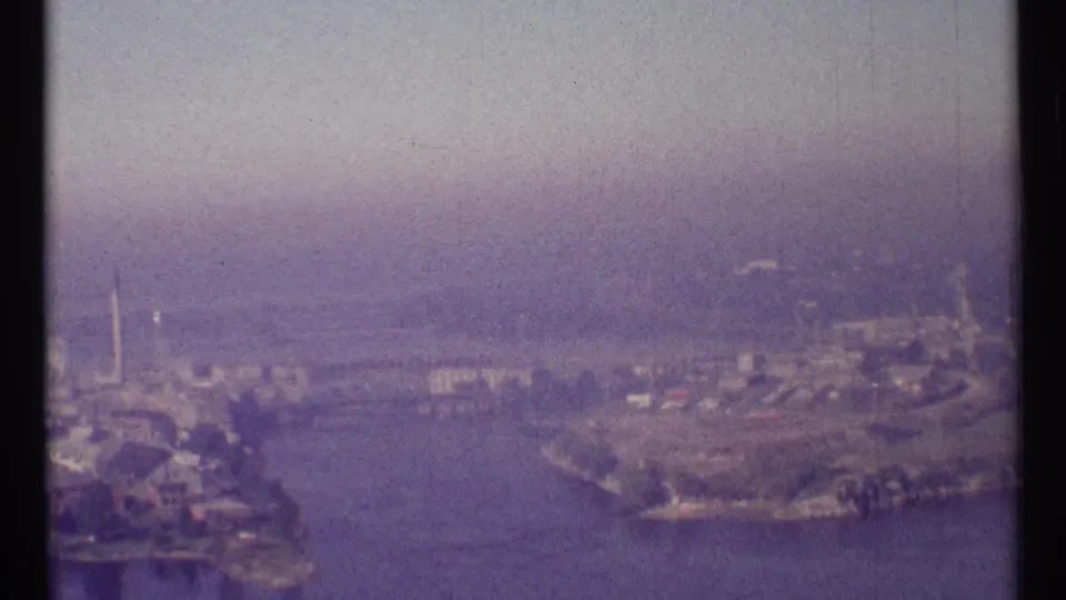 Ottawa, Canada, in 1967, seen from above with river water, developed shorelines, scattered buildings, and soft haze.
